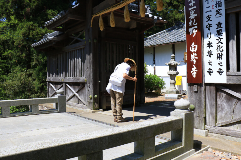 山門(仁王門)で合掌しているお遍路さん